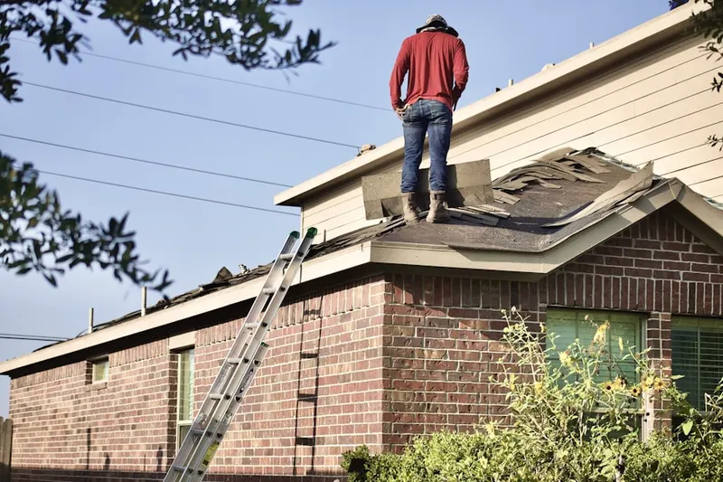 Professional roofer working on a residential roof in MacArthur Manor
